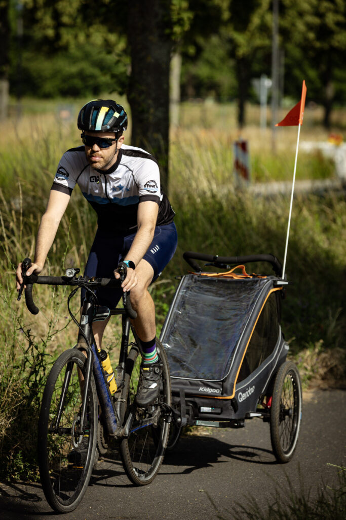 Konstantin rides home with the Qeridoo Kidgoo 1 hauling behind his Rose cross bike.